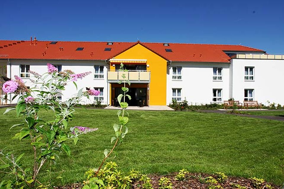 Die Rückseite des Hauses mit Grünfläche davor