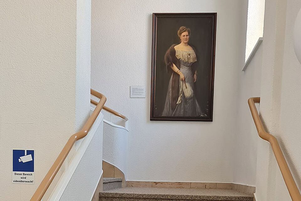 Treppenaufgang mit Blick auf ein großes Porträt-Gemälde der Namensgeberin Christiane von Breitenbach