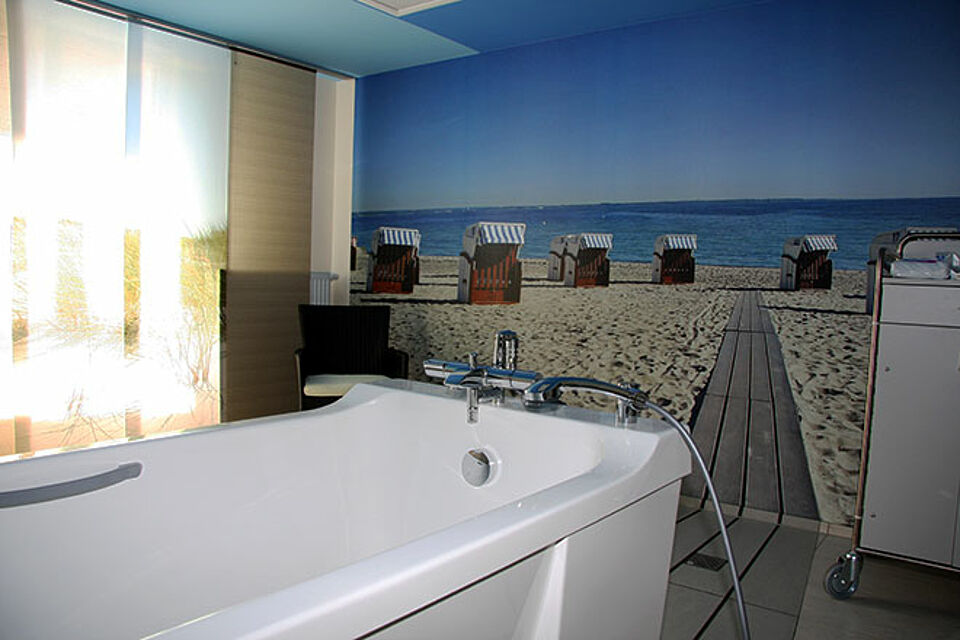 Badewanne vor Wand mit Strandbild von der Ostsee