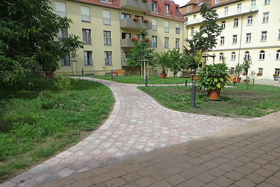 Blick auf die Grünfläche im Innenhof - ein Weg führt zwischen den Rasenflächen hindurch